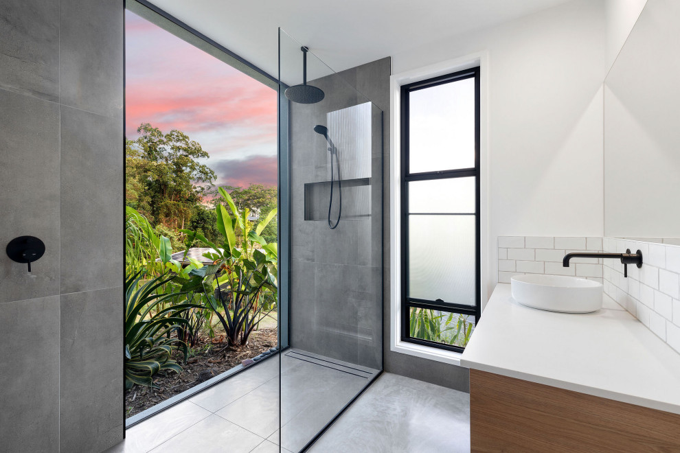 This is an example of a mid-sized contemporary 3/4 bathroom in Sunshine Coast with medium wood cabinets, an alcove shower, white tile, subway tile, white walls, a vessel sink, grey floor, an open shower, white benchtops, a niche and a floating vanity.