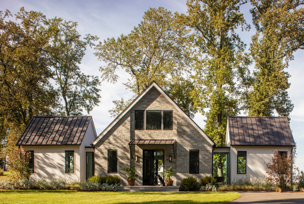Idées déco pour une très grande façade de maison grise campagne en pierre à un étage avec un toit en métal et un toit marron.
