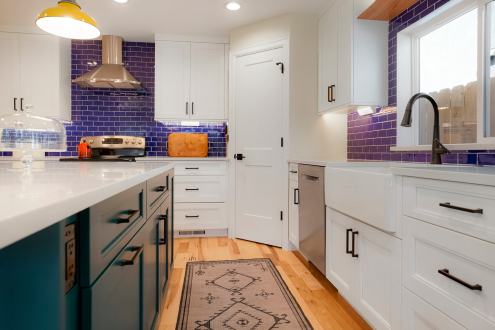 Inspiration for a large transitional l-shaped open plan kitchen in Denver with a farmhouse sink, recessed-panel cabinets, white cabinets, blue splashback, subway tile splashback, stainless steel appliances and with island.