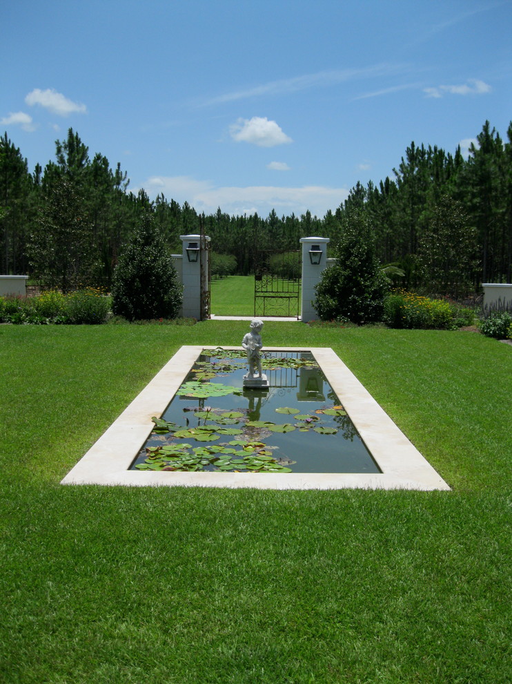 Photo of a traditional backyard full sun garden in Tampa with a water feature.