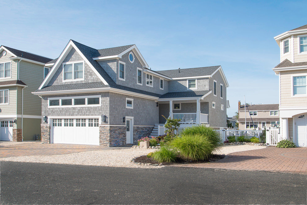Inspiration for a large beach style two-storey grey exterior in New York with mixed siding and a gable roof.