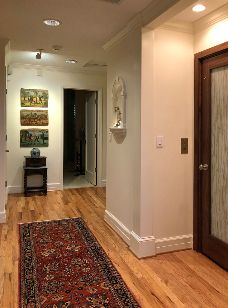 Mid-sized traditional hallway in Portland with white walls, medium hardwood floors and brown floor.