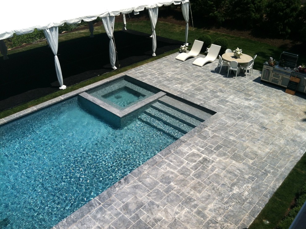 Large backyard stone and rectangular lap hot tub photo in New York