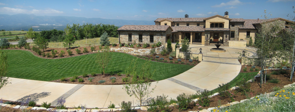 Large mediterranean front yard full sun driveway in Denver with a water feature and brick pavers for spring.