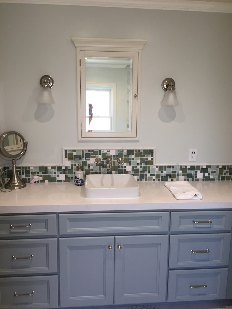 Photo of a mid-sized traditional master bathroom in Orange County with shaker cabinets, green cabinets, an alcove tub, a shower/bathtub combo, a one-piece toilet, gray tile, stone tile, green walls, porcelain floors, a vessel sink and engineered quartz benchtops.