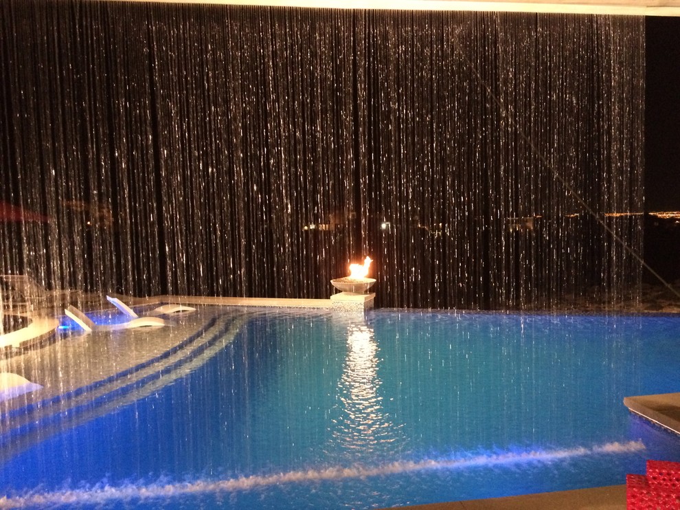 Idee per una grande piscina a sfioro infinito stile marino personalizzata dietro casa con fontane e piastrelle