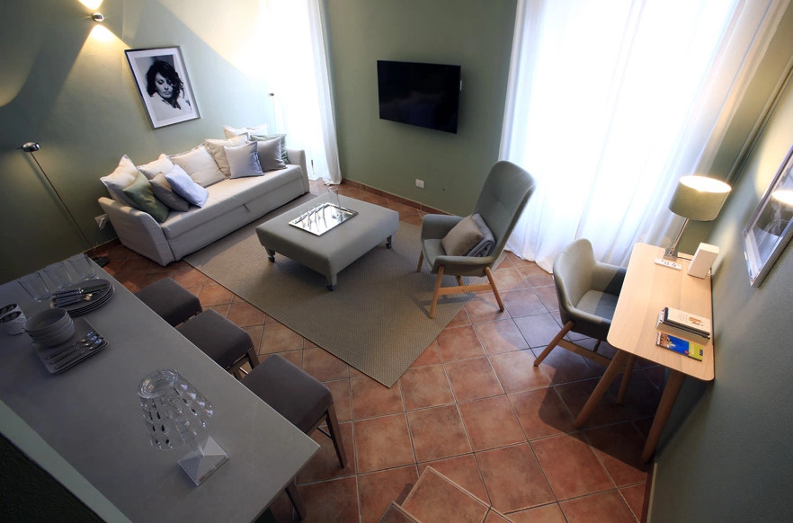 На фото: маленькая открытая гостиная комната в современном стиле с зелеными стенами, полом из терракотовой плитки, телевизором на стене и балками на потолке для на участке и в саду с