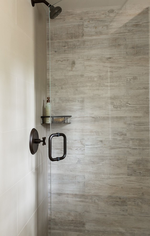 Photo of a mid-sized transitional bathroom in Boston with a one-piece toilet, gray tile, porcelain tile and ceramic floors.