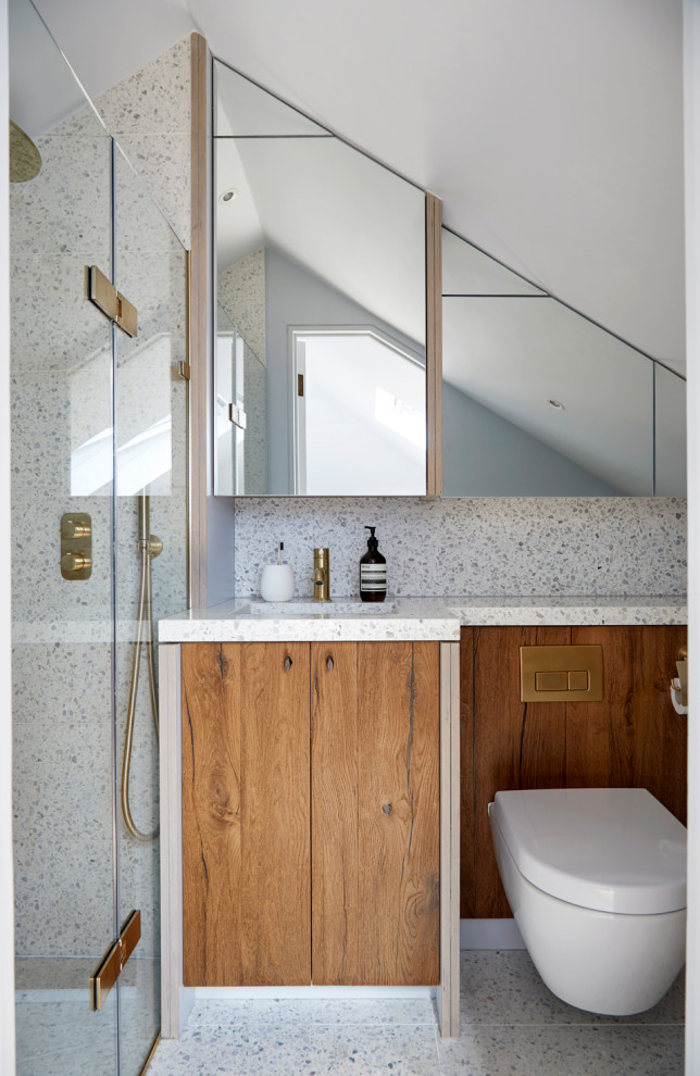 This is an example of a small country master bathroom in London with recessed-panel cabinets, an open shower, a wall-mount toilet, brown tile, ceramic tile, blue walls, terrazzo floors, a drop-in sink, terrazzo benchtops, a hinged shower door, grey benchtops, a single vanity and a built-in vanity.