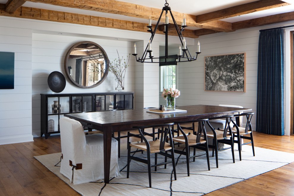 This is an example of an expansive farmhouse open plan dining room in Santa Barbara with white walls, medium hardwood flooring, a standard fireplace, a stone fireplace surround, brown floors, exposed beams and tongue and groove walls.