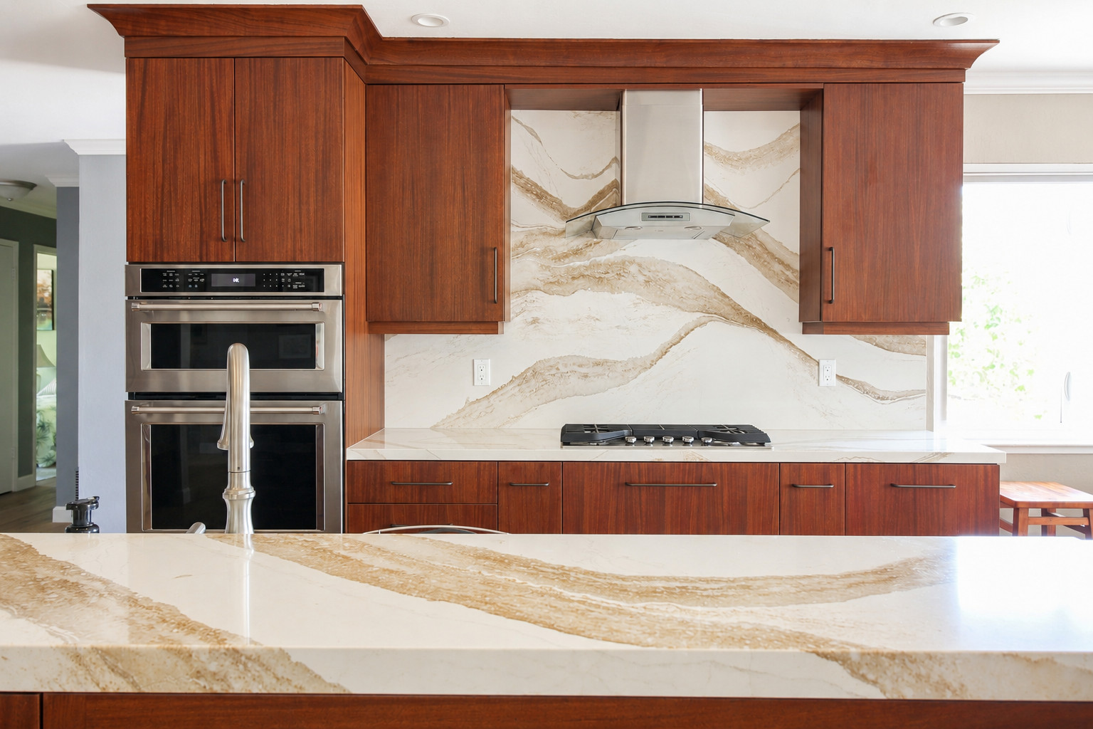 Inviting kitchen with mohagany cabinets and warm quartz counters with dramatic beige veining