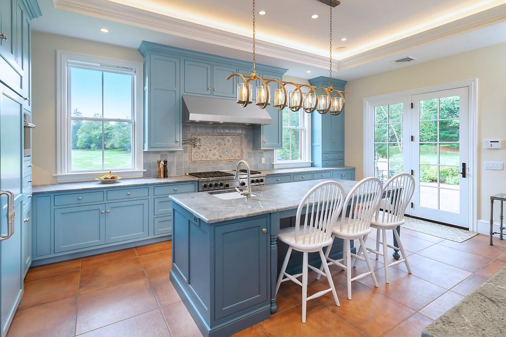 Photo of a large country l-shaped separate kitchen in Philadelphia with a farmhouse sink, beaded inset cabinets, blue cabinets, soapstone benchtops, blue splashback, ceramic splashback, panelled appliances, porcelain floors, with island, orange floor, black benchtop and recessed.