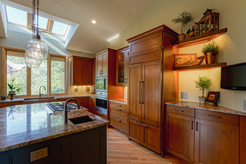 Inspiration for a mid-sized transitional medium tone wood floor and brown floor kitchen remodel in Denver with a farmhouse sink, recessed-panel cabinets, medium tone wood cabinets, granite countertops, paneled appliances and an island