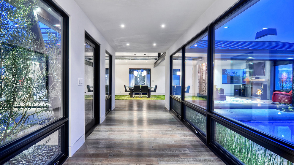 Photo of a large modern hallway in Orange County with white walls and dark hardwood floors.