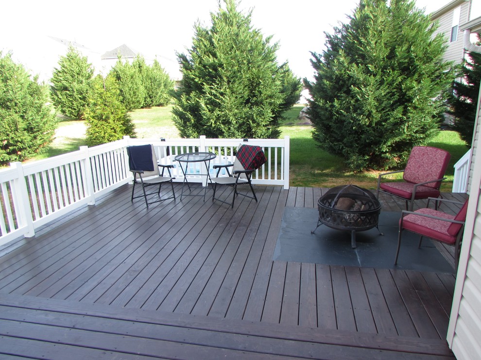 Example of a large transitional backyard deck design with a fire pit and no cover