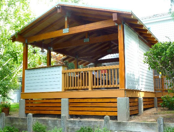 Inspiration for a large rustic backyard deck remodel in Boise with a roof extension