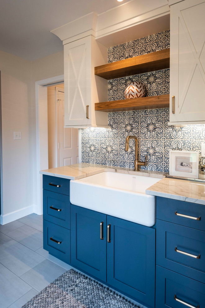 Inspiration for a large transitional utility room in Indianapolis with a farmhouse sink, shaker cabinets, blue cabinets, quartz benchtops, white walls, porcelain floors, a side-by-side washer and dryer, grey floor and white benchtop.
