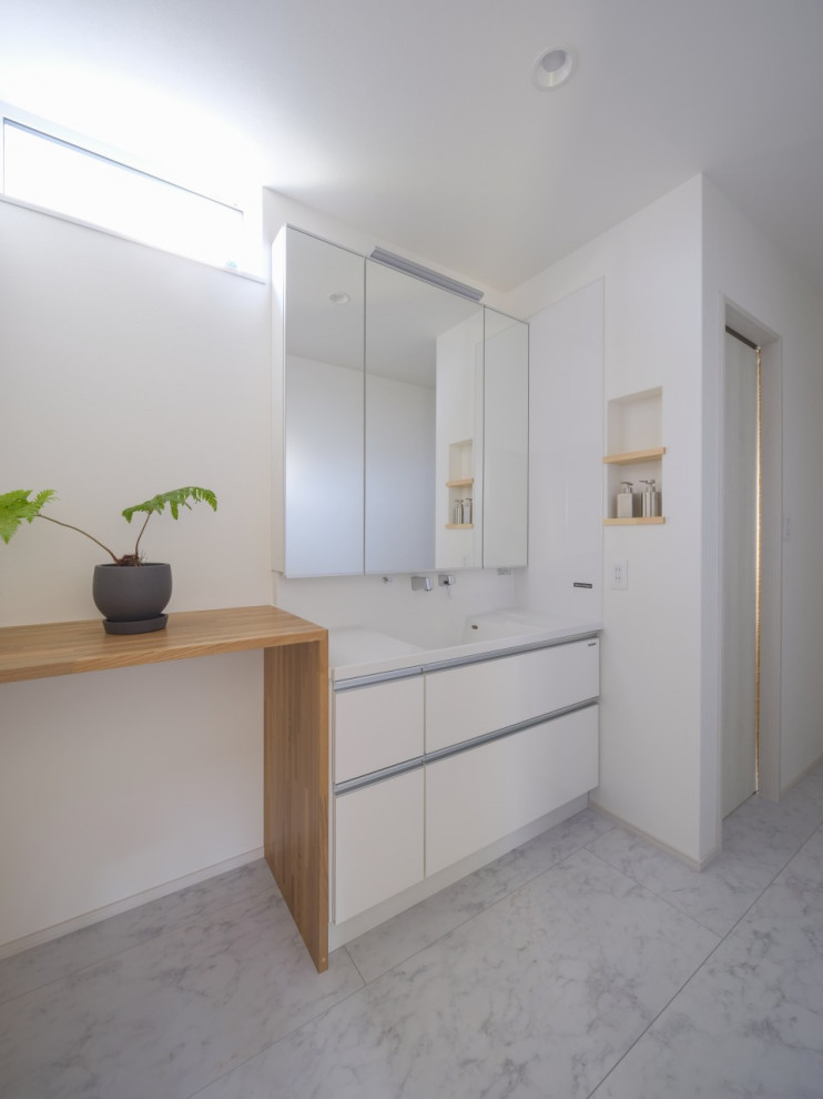 This is an example of a mid-sized modern powder room in Other with beaded inset cabinets, white cabinets, white tile, vinyl floors, solid surface benchtops, grey floor, white benchtops and wallpaper.