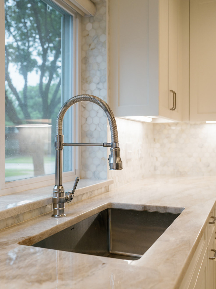 Inspiration for a large transitional u-shaped medium tone wood floor and brown floor enclosed kitchen remodel in Dallas with an undermount sink, raised-panel cabinets, beige cabinets, quartzite countertops, white backsplash, marble backsplash, stainless steel appliances, an island and beige countertops