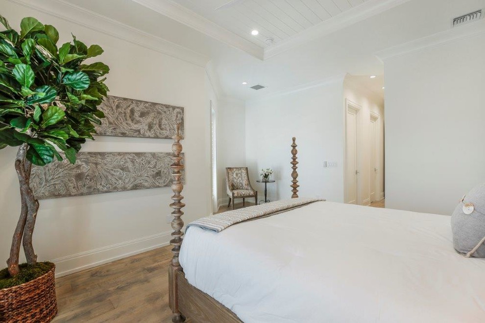Photo of a large beach style guest bedroom in Miami with white walls, medium hardwood floors and no fireplace.