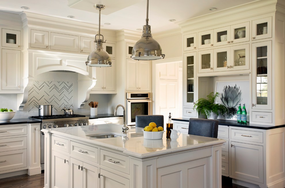 Inspiration for a large traditional u-shaped eat-in kitchen in Boston with an undermount sink, white cabinets, granite benchtops, white splashback, stainless steel appliances, dark hardwood floors, with island, subway tile splashback, brown floor, beaded inset cabinets and white benchtop.