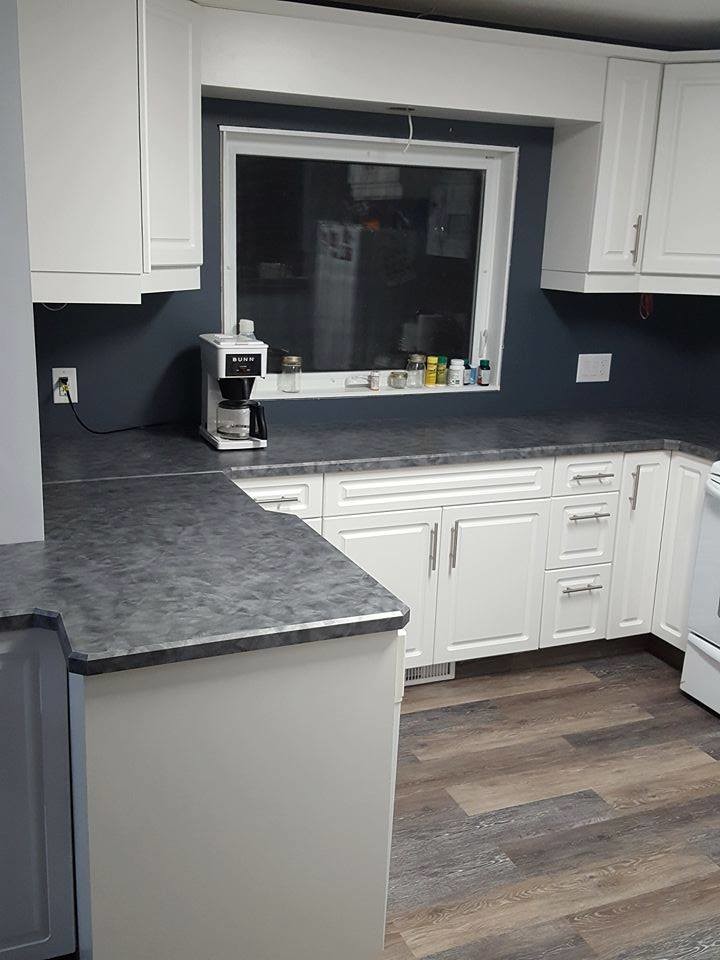 Kitchen - transitional medium tone wood floor and brown floor kitchen idea with a drop-in sink, raised-panel cabinets, white cabinets, white appliances and laminate countertops