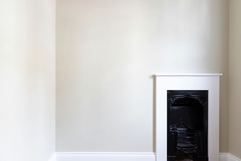 Modelo de habitación de invitados blanca y blanca y madera clásica pequeña con paredes blancas, suelo de madera oscura, todas las chimeneas, marco de chimenea de yeso y suelo marrón