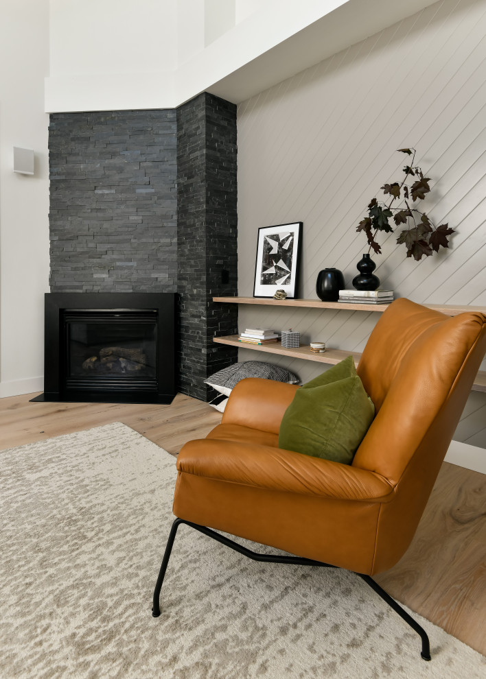 Idée de décoration pour un salon minimaliste de taille moyenne et ouvert avec un mur blanc, un sol en bois brun, une cheminée d'angle, un manteau de cheminée en pierre, un téléviseur indépendant, un sol jaune, un plafond voûté et du lambris.