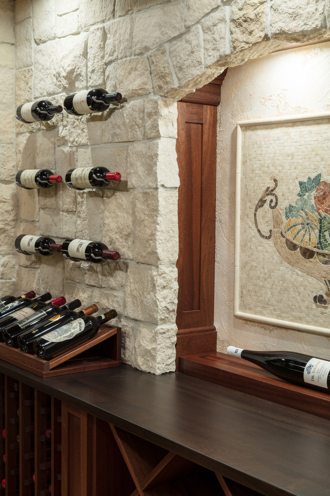 Photo of a mid-sized traditional wine cellar in Boston with travertine floors, storage racks and beige floor.