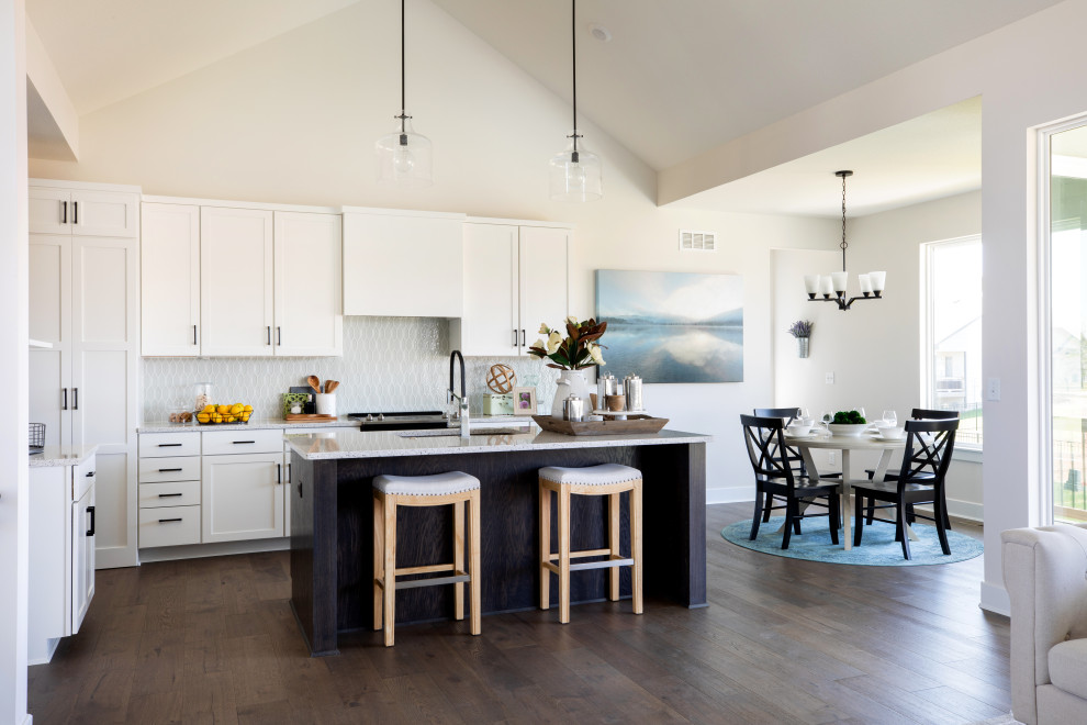 Inspiration for a large country l-shaped open plan kitchen in Wichita with white cabinets, quartz benchtops, with island, an undermount sink, shaker cabinets, grey splashback, porcelain splashback, stainless steel appliances, medium hardwood floors, brown floor, multi-coloured benchtop and vaulted.