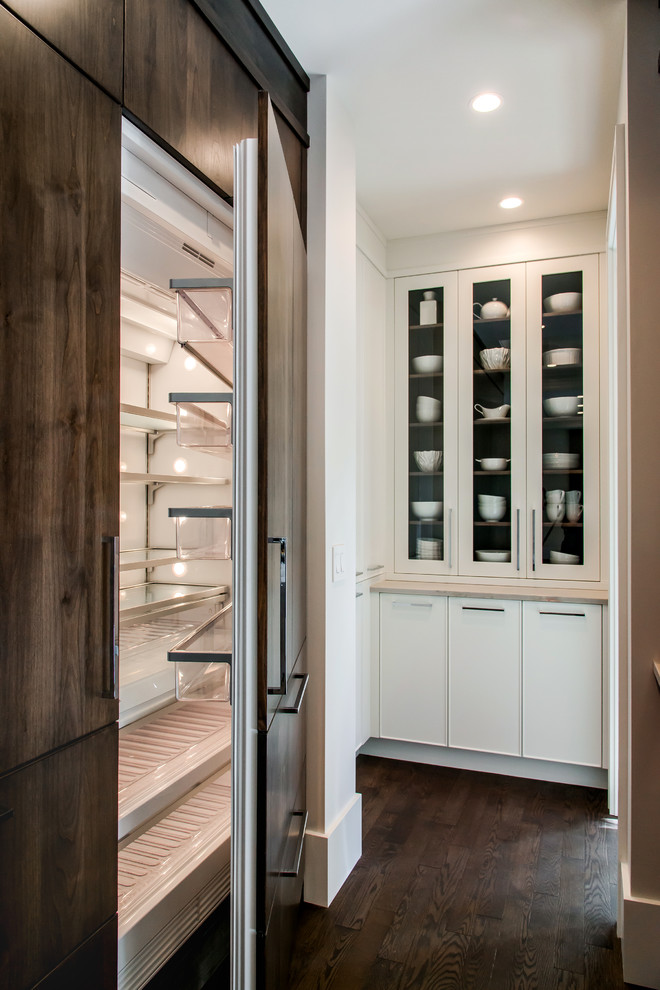 Example of a large transitional l-shaped medium tone wood floor kitchen pantry design in Calgary with a double-bowl sink, flat-panel cabinets, marble countertops, white backsplash, stone slab backsplash, paneled appliances and an island