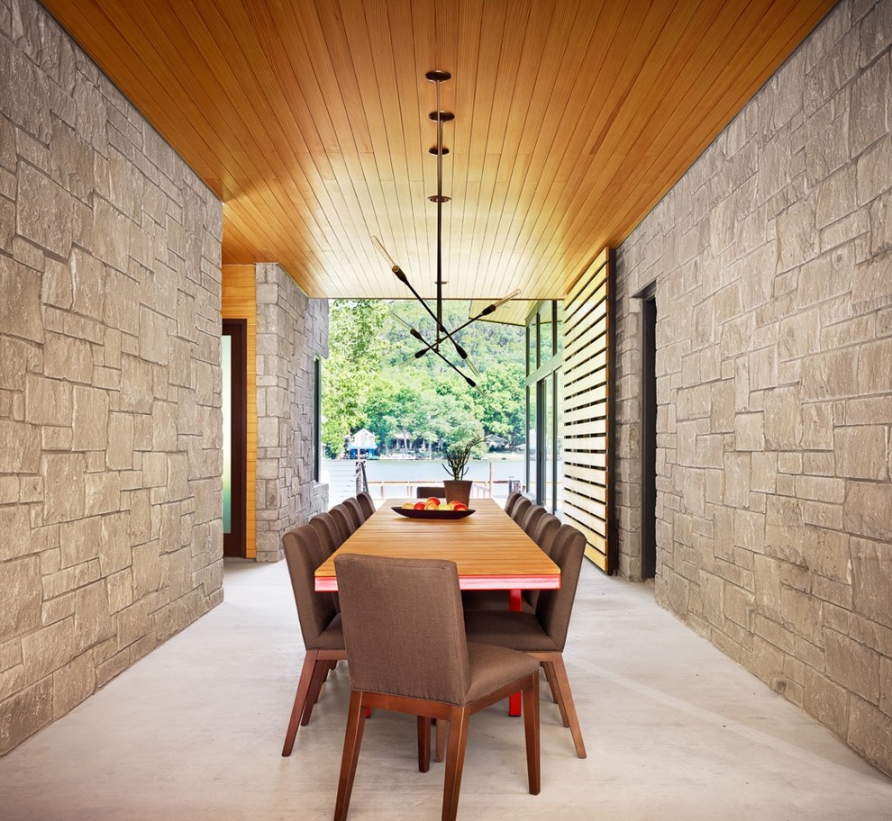 This is an example of a large modern dining room in Austin with beige walls and concrete floors.