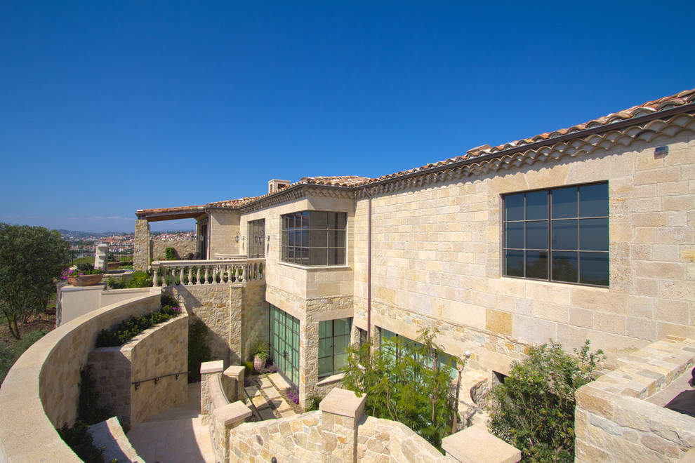 This is an example of a large mediterranean three-storey grey exterior in Santa Barbara with stone veneer.