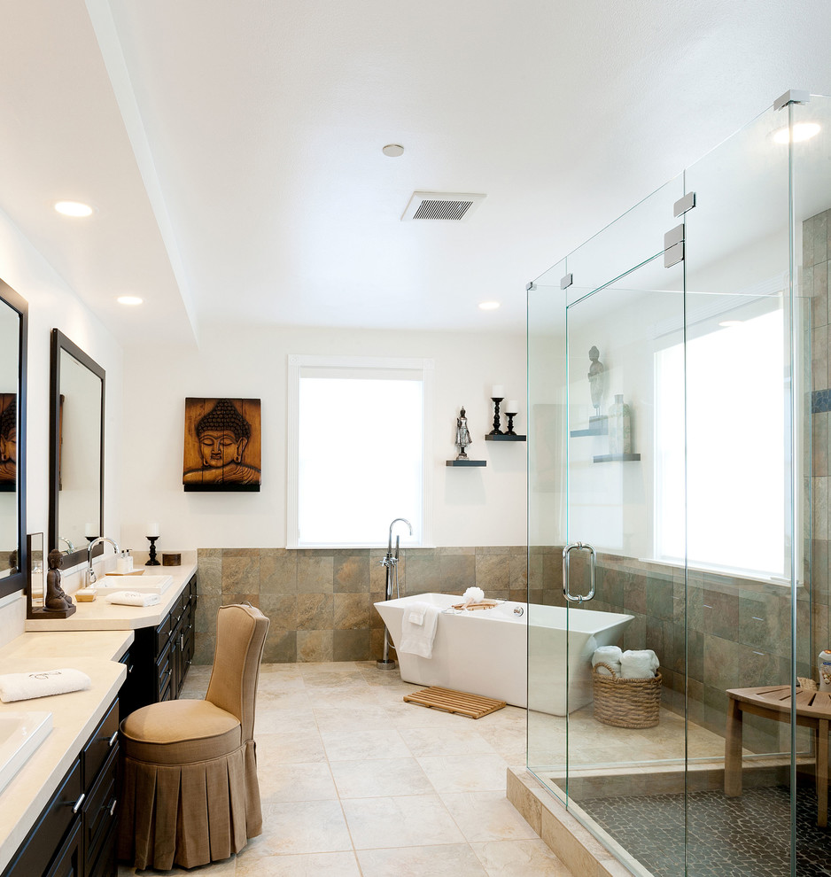 Large eclectic master bathroom in Los Angeles with an open shower, multi-coloured tile, pebble tile floors, a drop-in sink, raised-panel cabinets, dark wood cabinets, a freestanding tub and beige walls.