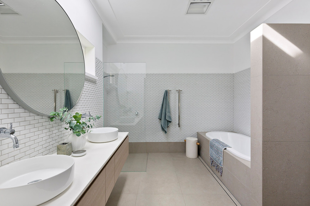 Photo of a large contemporary 3/4 wet room bathroom in Sydney with light wood cabinets, a drop-in tub, white tile, mosaic tile, cement tiles, solid surface benchtops, an open shower, white benchtops, an enclosed toilet, a double vanity and a floating vanity.