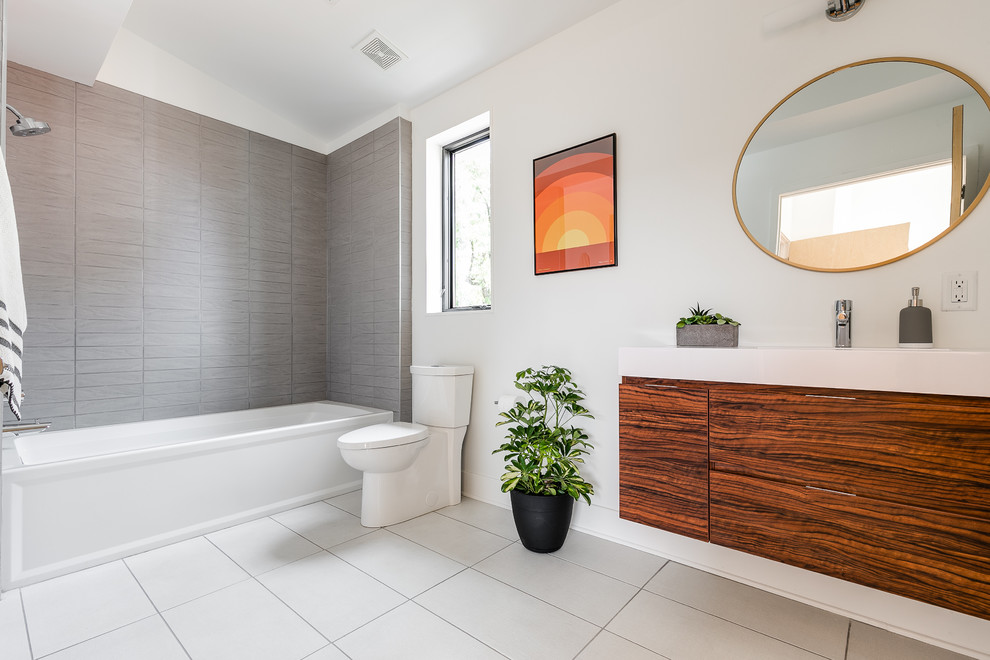 Photo of a modern kids bathroom in DC Metro with an alcove tub, an alcove shower, a two-piece toilet, white tile, porcelain tile, white walls and porcelain floors.