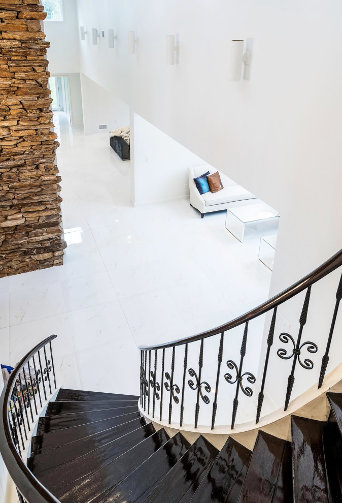 Источник вдохновения для домашнего уюта: изогнутая лестница в стиле модернизм с крашенными деревянными ступенями, крашенными деревянными подступенками и металлическими перилами