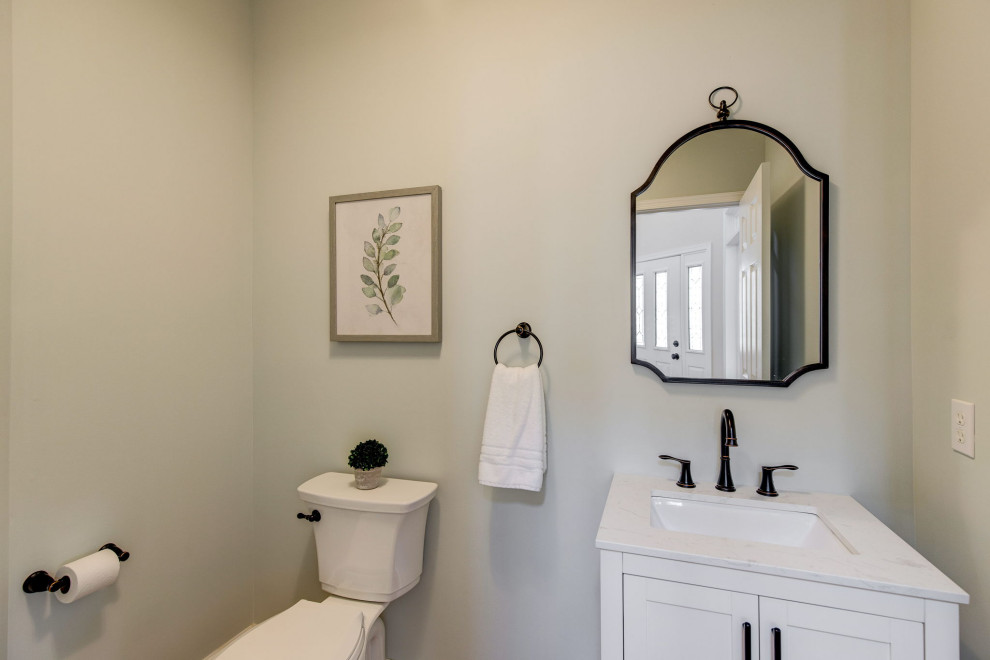 Inspiration for a mid-sized traditional powder room in Philadelphia with shaker cabinets, white cabinets, a two-piece toilet, blue walls, medium hardwood floors, an undermount sink, marble benchtops, white benchtops and a freestanding vanity.