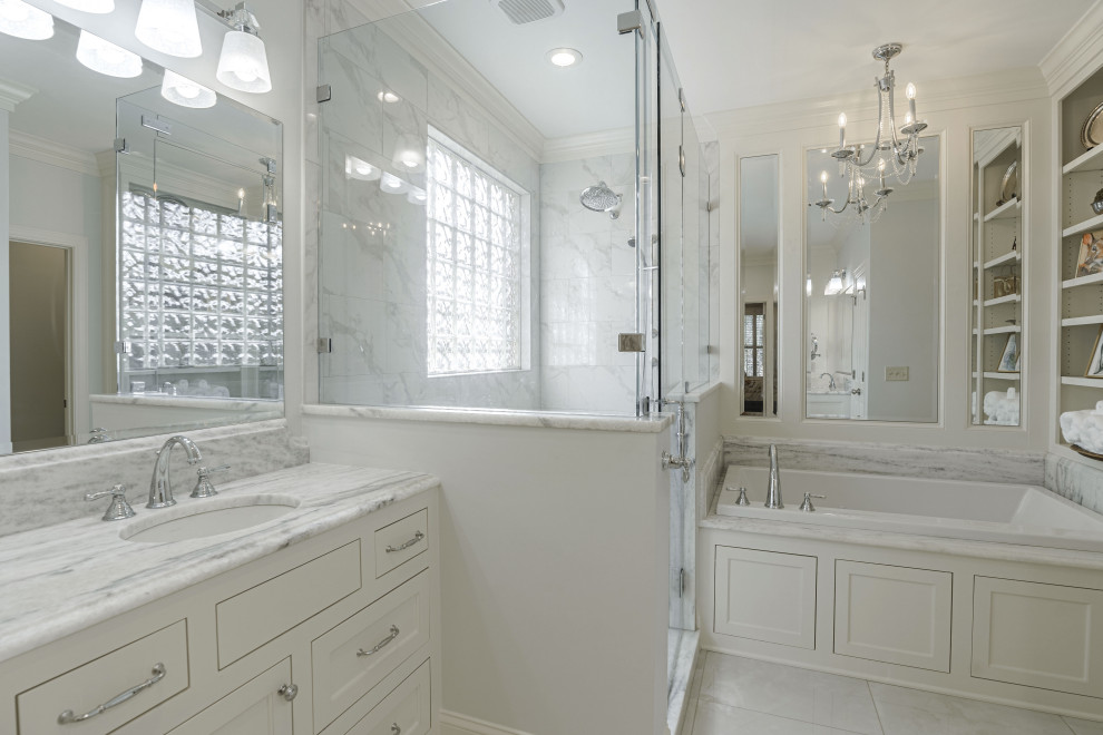 На фото: большая главная ванная комната в классическом стиле с фасадами с утопленной филенкой, белыми фасадами, ванной в нише, открытым душем, раздельным унитазом, белой плиткой, плиткой из листового камня, белыми стенами, полом из керамогранита, врезной раковиной, мраморной столешницей, белым полом, душем с распашными дверями, белой столешницей, тумбой под одну раковину и встроенной тумбой с