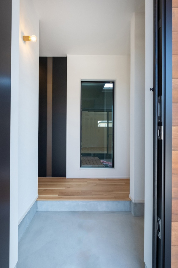 Idées déco pour une entrée avec un couloir, un mur blanc, un sol en bois brun, une porte simple, une porte noire, un plafond en papier peint et du papier peint.