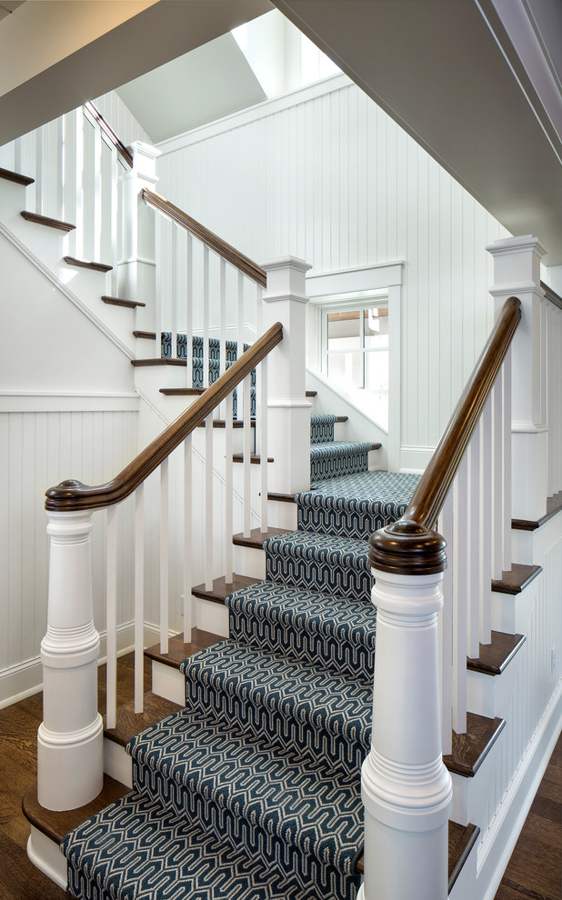 This is an example of a mid-sized beach style wood l-shaped staircase in Minneapolis with painted wood risers and wood railing.