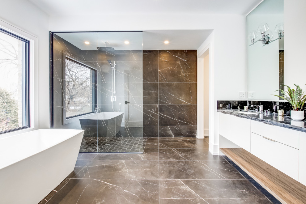 Mid-sized contemporary master bathroom in Toronto with white cabinets, a freestanding tub, a curbless shower, a one-piece toilet, black and white tile, marble, white walls, marble floors, marble benchtops, black floor, an open shower, black benchtops, flat-panel cabinets, an undermount sink, a double vanity and a built-in vanity.