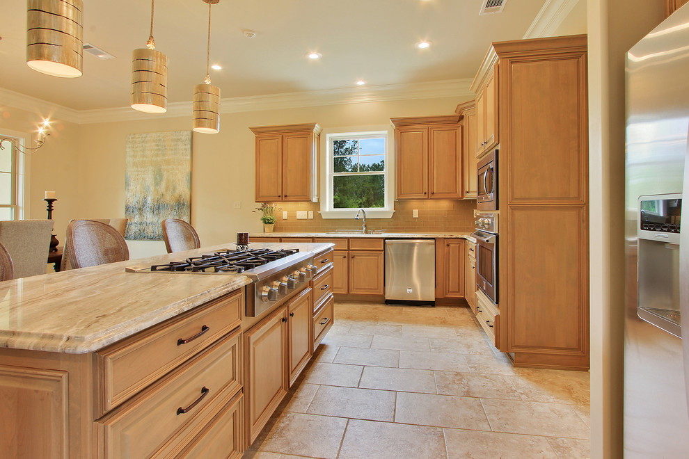 Design ideas for a mid-sized transitional l-shaped open plan kitchen in New Orleans with recessed-panel cabinets, light wood cabinets, quartzite benchtops, yellow splashback, ceramic splashback, stainless steel appliances, porcelain floors, with island, beige floor and beige benchtop.