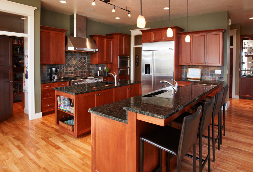 Example of a large transitional u-shaped light wood floor eat-in kitchen design with a drop-in sink, medium tone wood cabinets, granite countertops, multicolored backsplash, stainless steel appliances, an island and recessed-panel cabinets