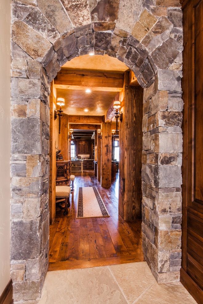 Example of a large mountain style dark wood floor hallway design with beige walls