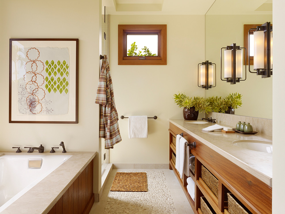 Inspiration for a tropical bathroom in Hawaii with an undermount sink, open cabinets, medium wood cabinets, an undermount tub, an alcove shower, pebble tile floors and beige floor.