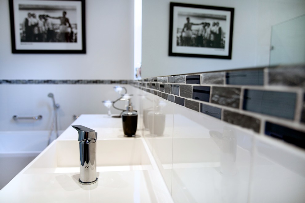 Large modern master bathroom in Adelaide with open cabinets, white cabinets, a drop-in tub, a curbless shower, a two-piece toilet, black and white tile, ceramic tile, white walls, cement tiles, an integrated sink, laminate benchtops, grey floor, a hinged shower door and white benchtops.