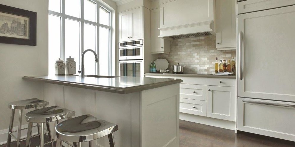 Kitchen - small transitional galley dark wood floor and brown floor kitchen idea in Miami with an undermount sink, shaker cabinets, white cabinets, granite countertops, beige backsplash, stone tile backsplash, paneled appliances and a peninsula