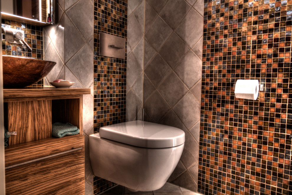 Exemple d'un petit WC suspendu chic en bois brun avec un placard à porte plane, un carrelage beige, mosaïque, un mur beige, un sol en carrelage de céramique, une vasque, un plan de toilette en verre, un sol beige, un plan de toilette marron, meuble-lavabo suspendu et un plafond décaissé.