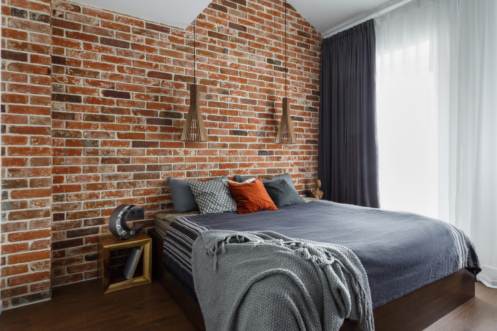 Design ideas for a large industrial bedroom in Moscow with red walls, dark hardwood floors, brown floor, vaulted and brick walls.